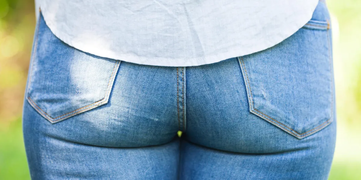 close up picture of a young woman's butt dressed with blue jeans outdoor