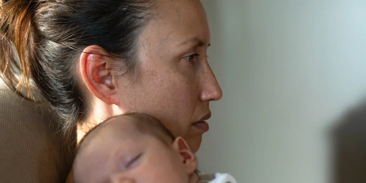 a sad mother sitting at home suffering from postpartum depression motherhood problems