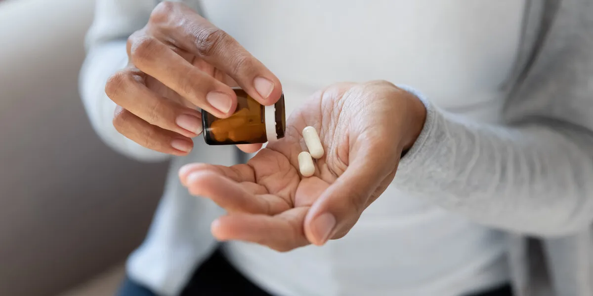 crop close up of african american woman take pills or tablets from bottle biracial female have nutritional dietary supplements or medicines from packaging healthcare, pharmacy, wellness concept crop close up of african american woman take pills or tablets from bottle biracial female have nutritional dietary supplements or medicines from packaging healthcare, pharmacy, wellness concept