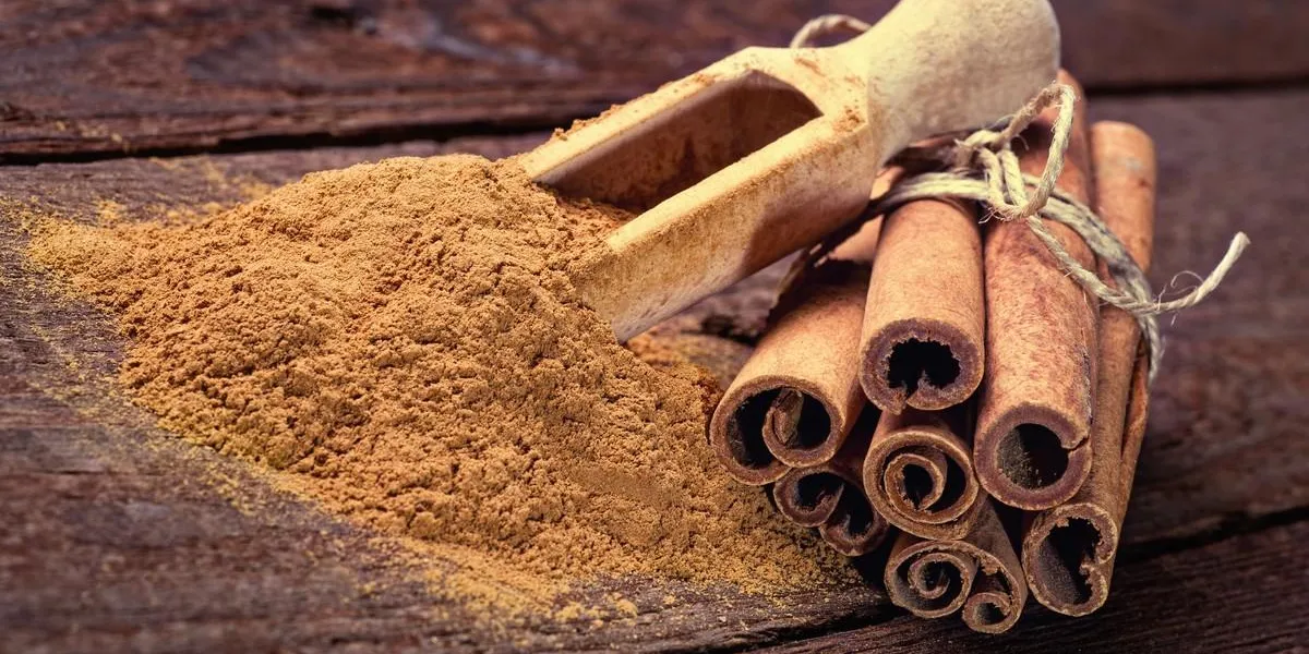 cinnamon sticks and cinnamon powder on wood floor