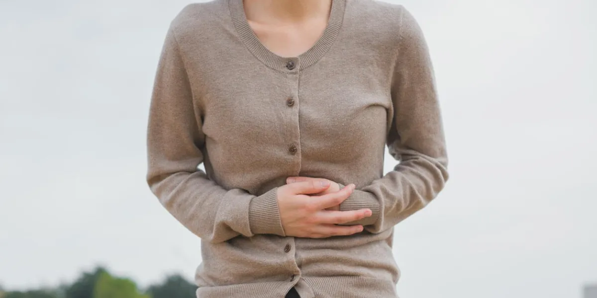 woman holding her stomach woman holding her stomach