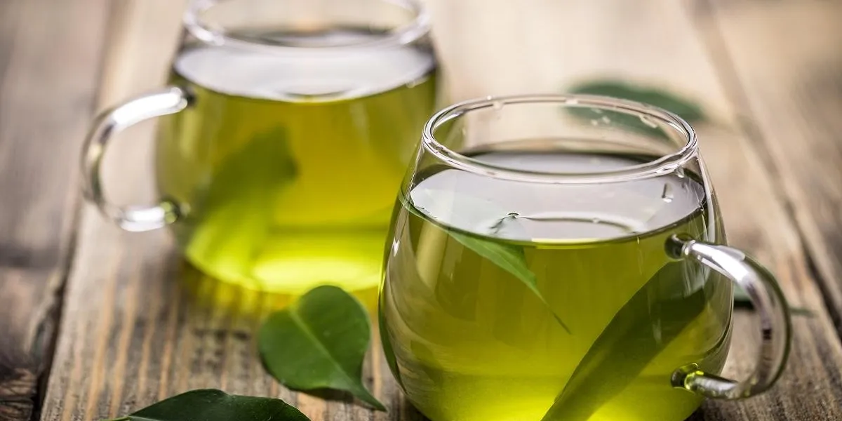 fresh green tea with tea leaves in the water fresh green tea with tea leaves in the water