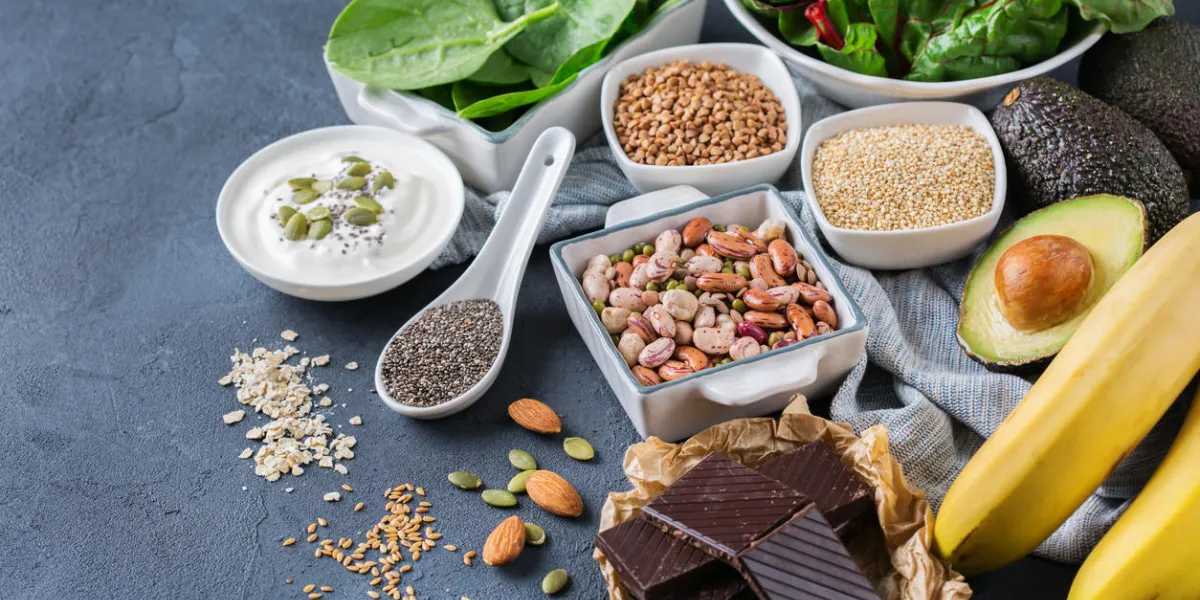 healthy food nutrition dieting concept assortment of high magnesium sources banana chocolate spinach chard, avocado, buckwheat, sesame chia flax seeds, yogurt, nuts, beans oat copy space background healthy food nutrition dieting concept assortment of high magnesium sources banana chocolate spinach chard, avocado, buckwheat, sesame chia flax seeds, yogurt, nuts, beans oat copy space background