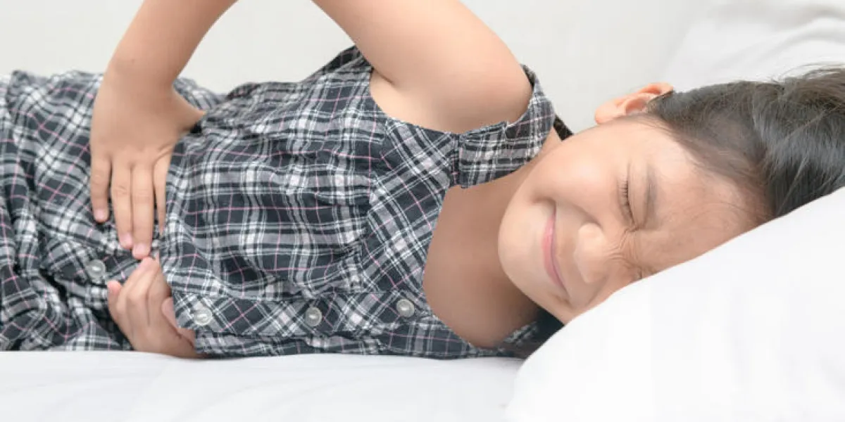 asian child suffering from stomachache and lying on bed diarrhea or healthy concept