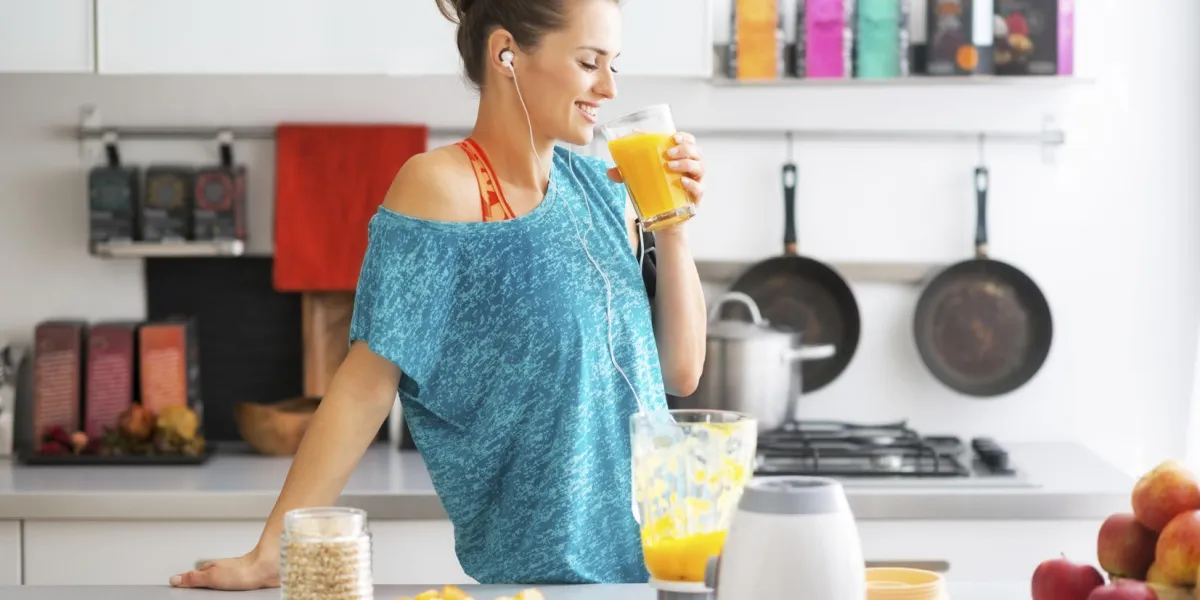 bonne forme physique jeune femme buvant smoothie citrouille dans la cuisine