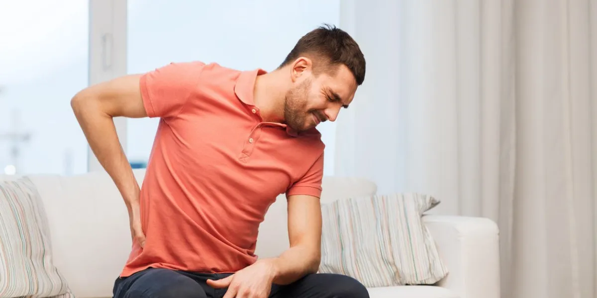 gens, soins de santé et concept de problème - malheureux homme souffrant de douleurs dans le dos ou les rênes à la maison