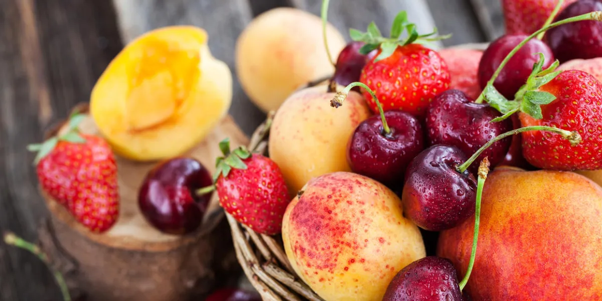 fresh ripe summer berries and fruits (peaches, apricots, cherry and strawberry) in wicker basket fresh ripe summer berries and fruits (peaches, apricots, cherry and strawberry) in wicker basket