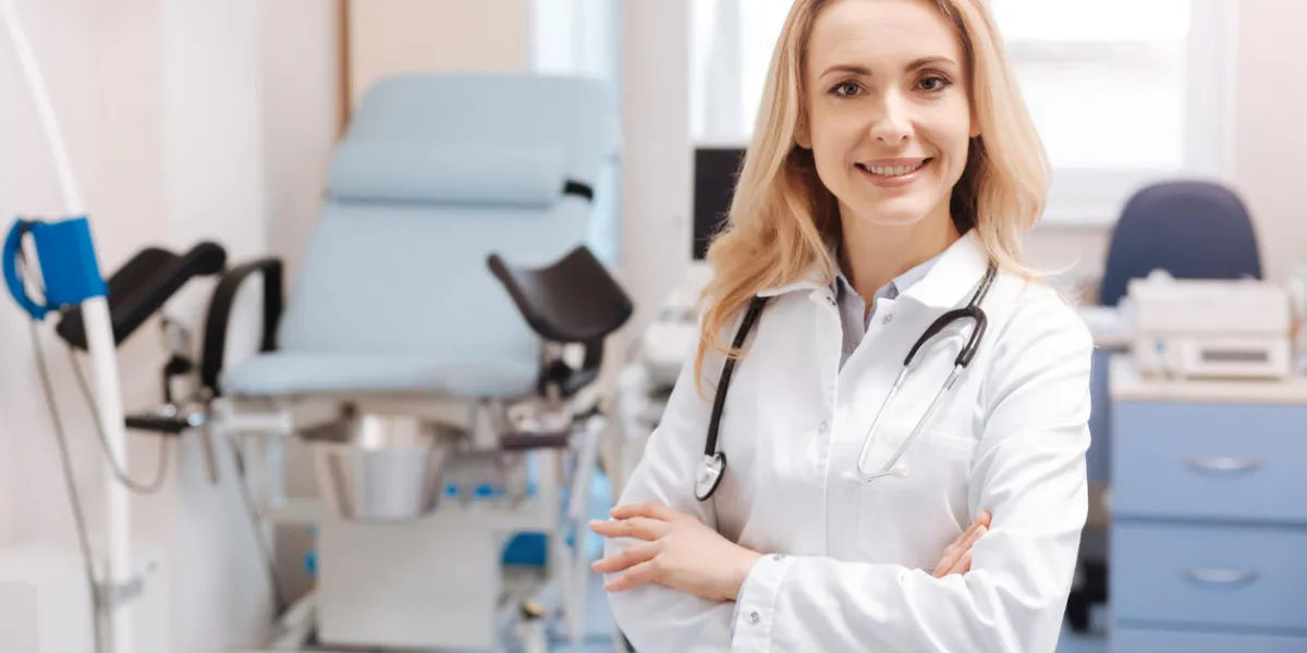 full of joyful emotions at work positive delighted qualified gynecologist standing in the gynecology cabinet while expressing positivity and enjoying working responsibilities