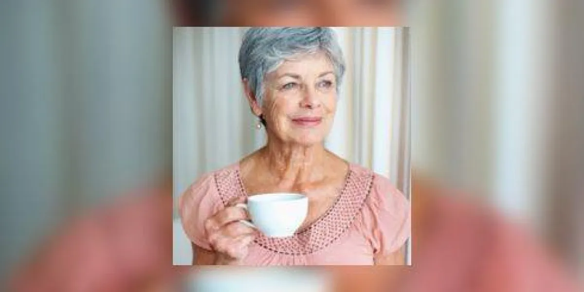 une femme senior avec une tasse de café en regardant loin et souriant une femme senior avec une tasse de café en regardant loin et souriant