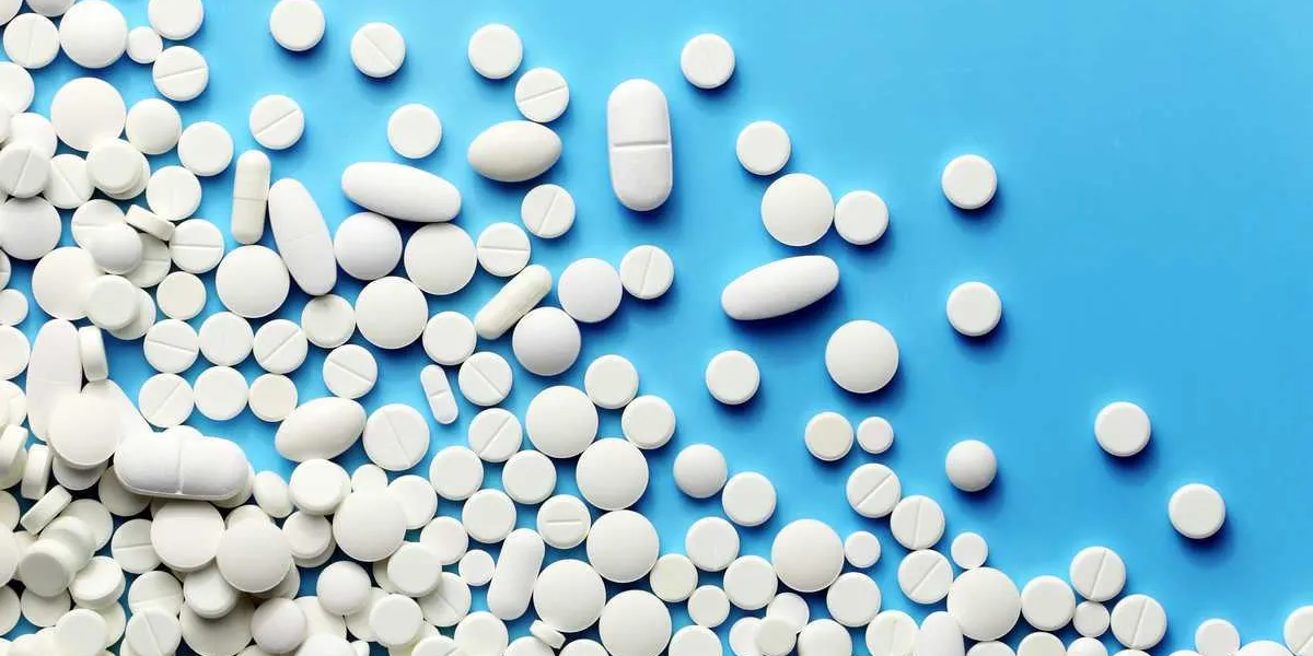 white medicine pills on a blue white medicine pills on a blue