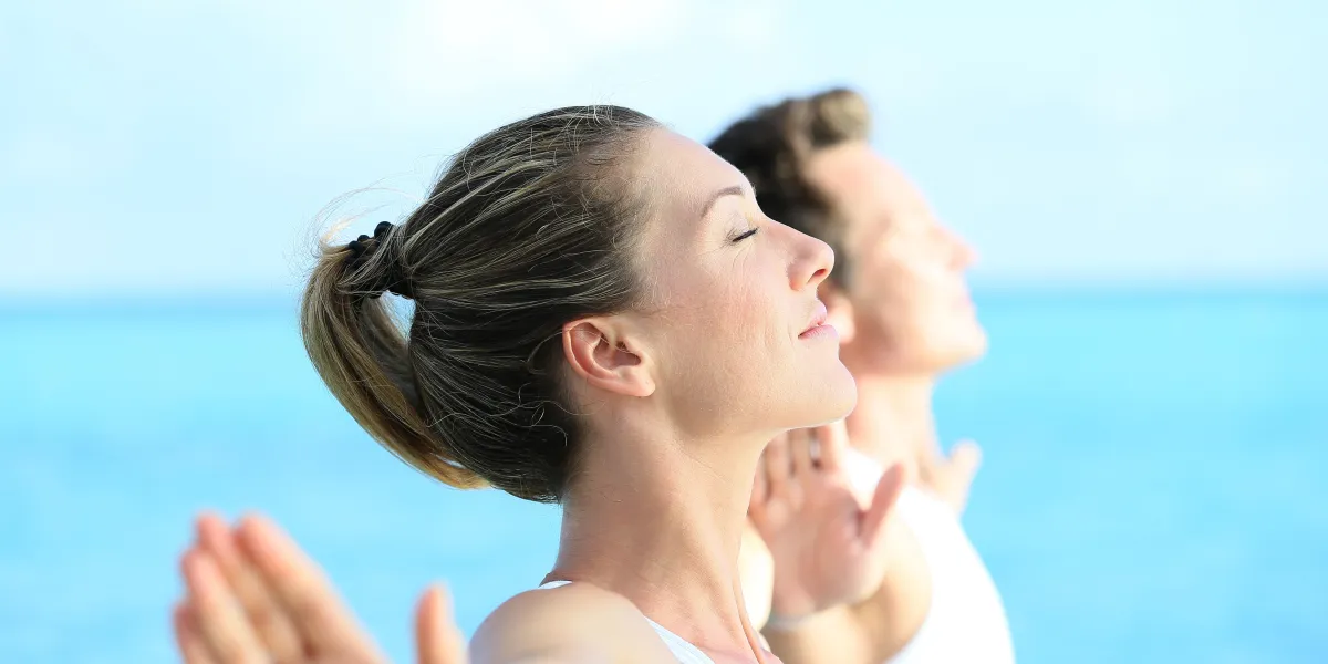 couple faisant des exercices de yoga et de relaxation au bord de la mer couple faisant des exercices de yoga et de relaxation au bord de la mer