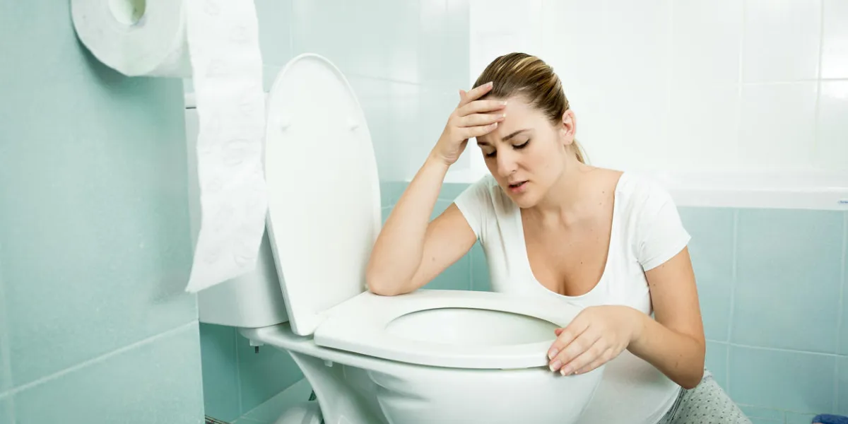 pregnant young woman leaning on toilet and feeling sick
