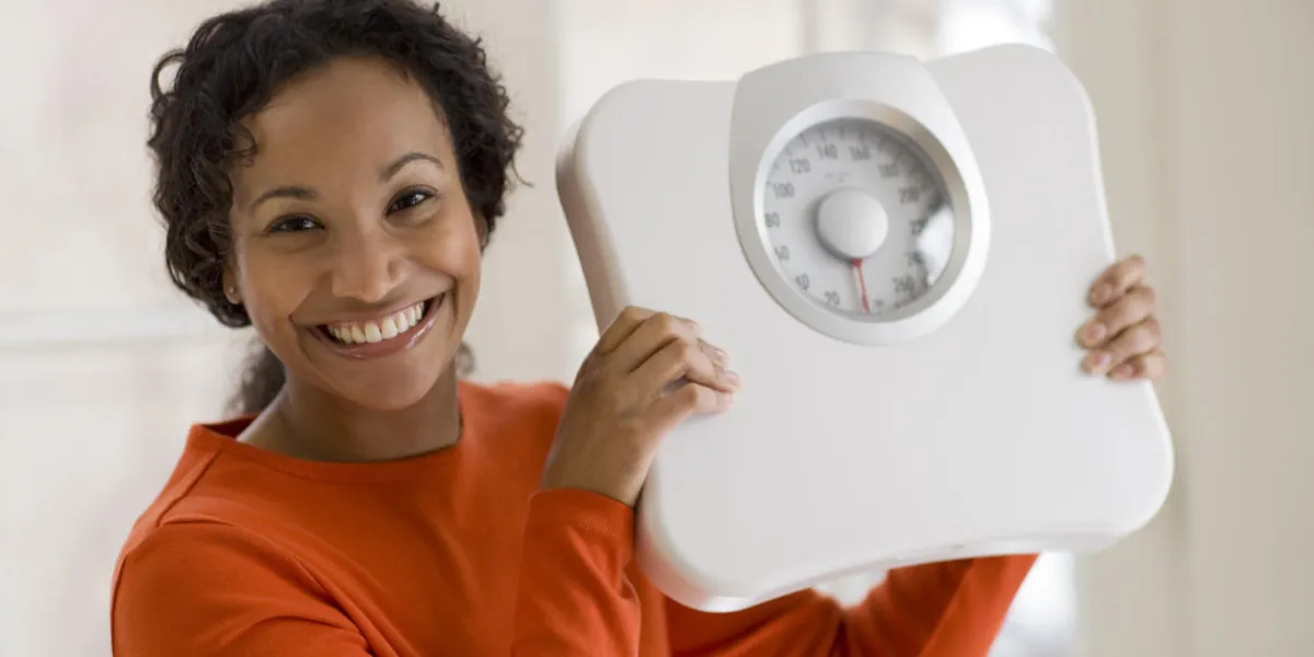beautiful african american woman holding scale