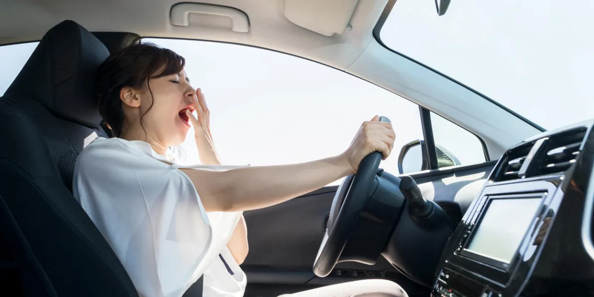 yawning female driver falling asleep at the wheel concept