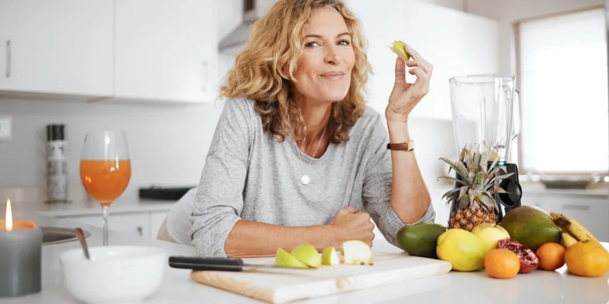 portrait, fruit salad and apple with a senior woman in the kitchen of her home for health, diet or nutrition smile, food and cooking with a happy mature female pension eating healthy in the house portrait, fruit salad and apple with a senior woman in the kitchen of her home for health, diet or nutrition smile, food and cooking with a happy mature female pension eating healthy in the house