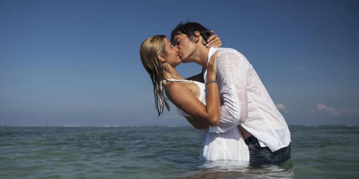 attractive couple kissing in ocean attractive couple kissing in ocean
