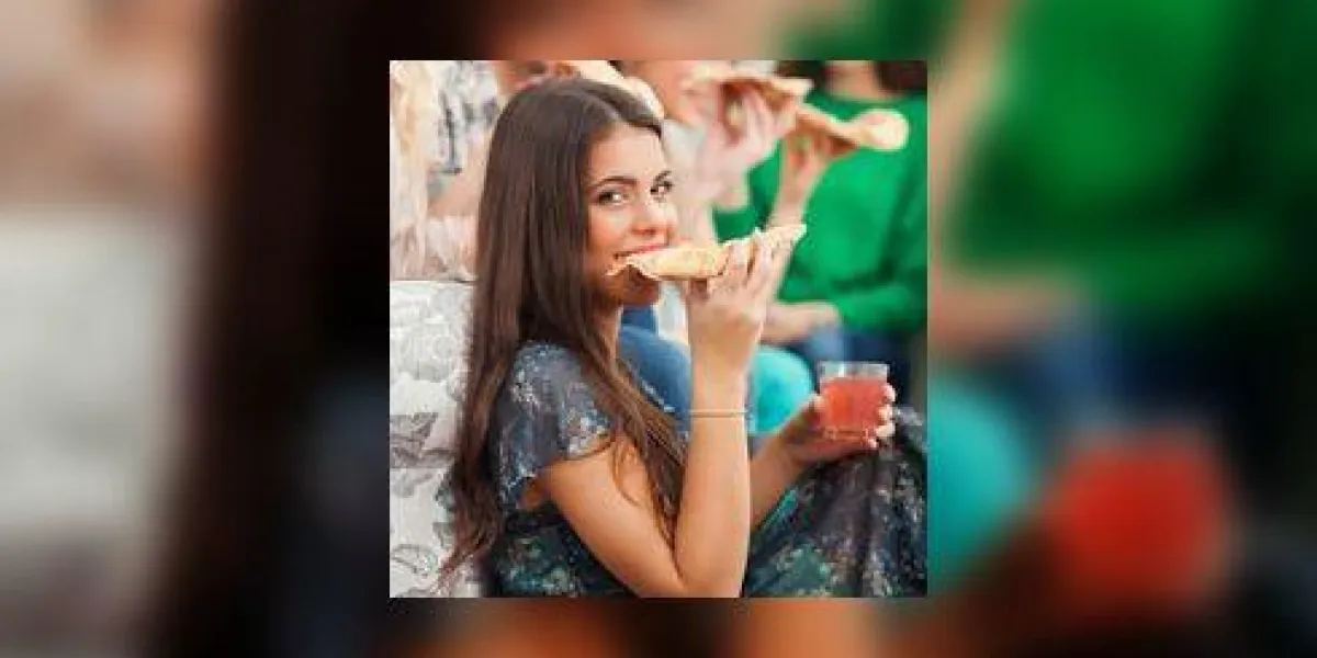 belle jeune fille mangeant une pizza avec ses amis à la maison