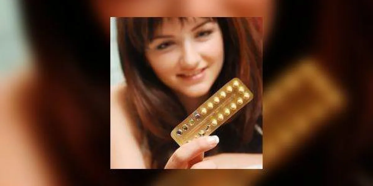 une jolie jeune femme regarde ses pilules contraceptives et sourit peu profond, l'accent est mis sur les pilules une jolie jeune femme regarde ses pilules contraceptives et sourit peu profond, l'accent est mis sur les pilules