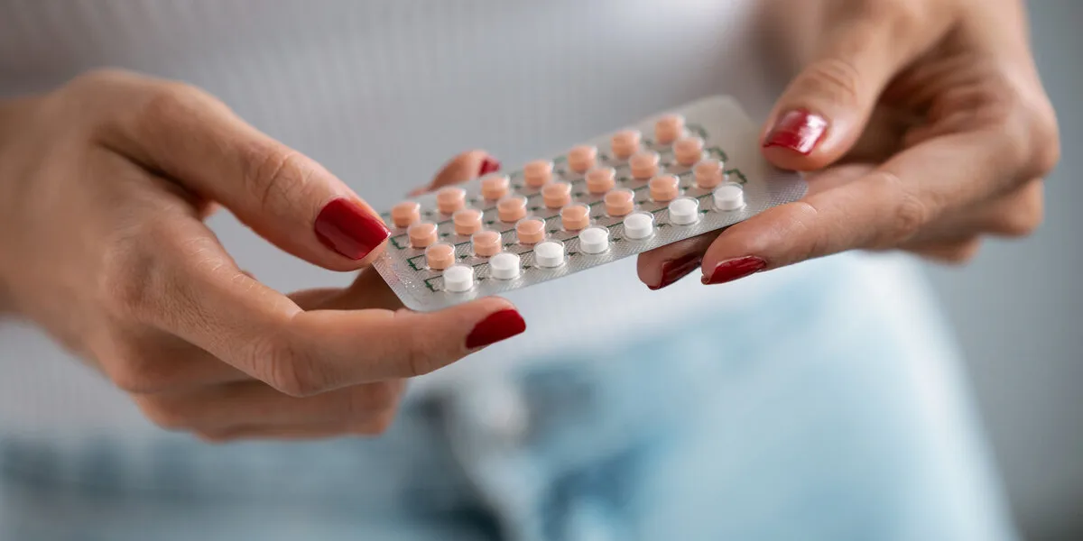 close-up of woman holding a contraceptive pills concept of contraception methods