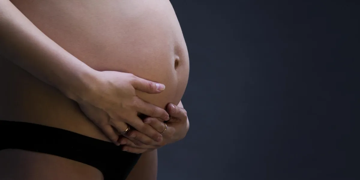 pregnant belly close up on gray background with copy space studio shot pregnant belly close up on gray background with copy space studio shot