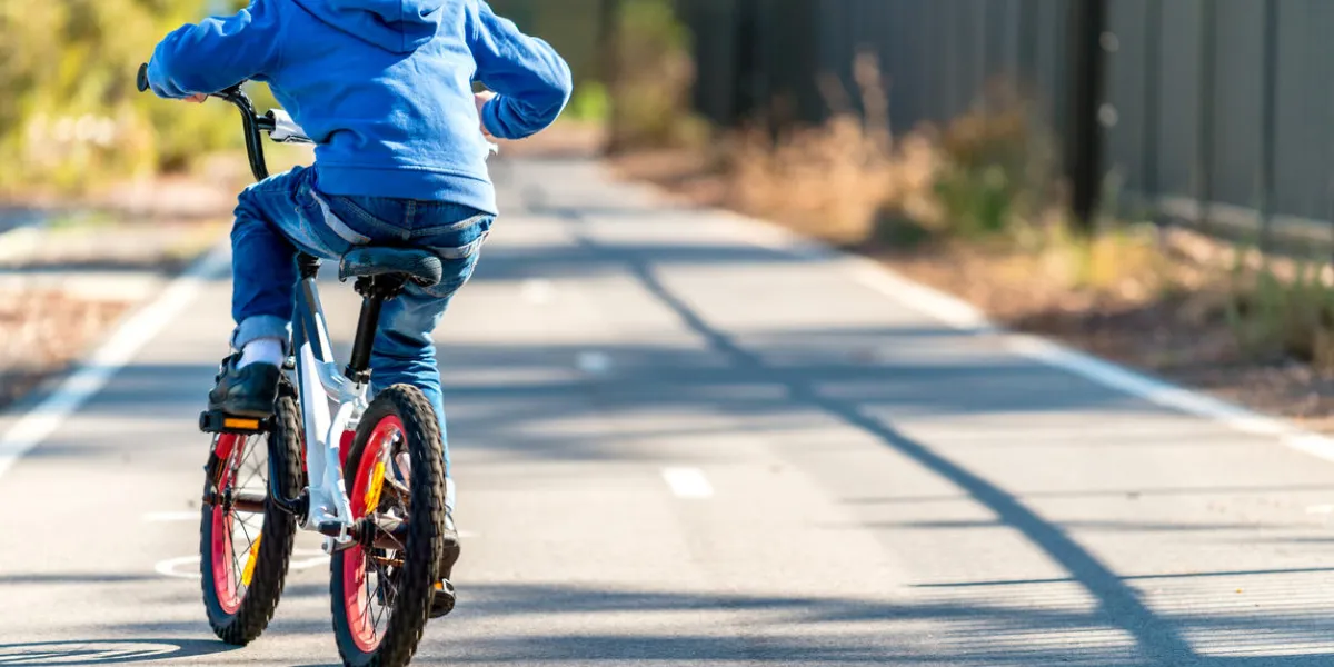 australian boy riding his bicycle on bike lane on a day, south australia