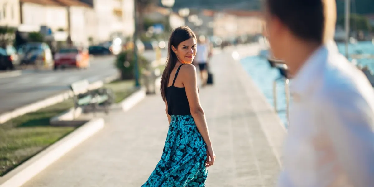 young attractive woman flirting with a man on the streetflirty smiling woman looking back on a handsome manfemale attractionlove at first sightmeeting ex boyfriend
