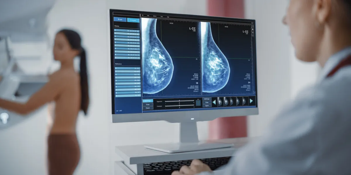 computer screen in hospital radiology room beautiful multiethnic adult woman standing topless undergoing mammography screening procedure screen showing the mammogram scans of dense breast tissues computer screen in hospital radiology room beautiful multiethnic adult woman standing topless undergoing mammography screening procedure screen showing the mammogram scans of dense breast tissues