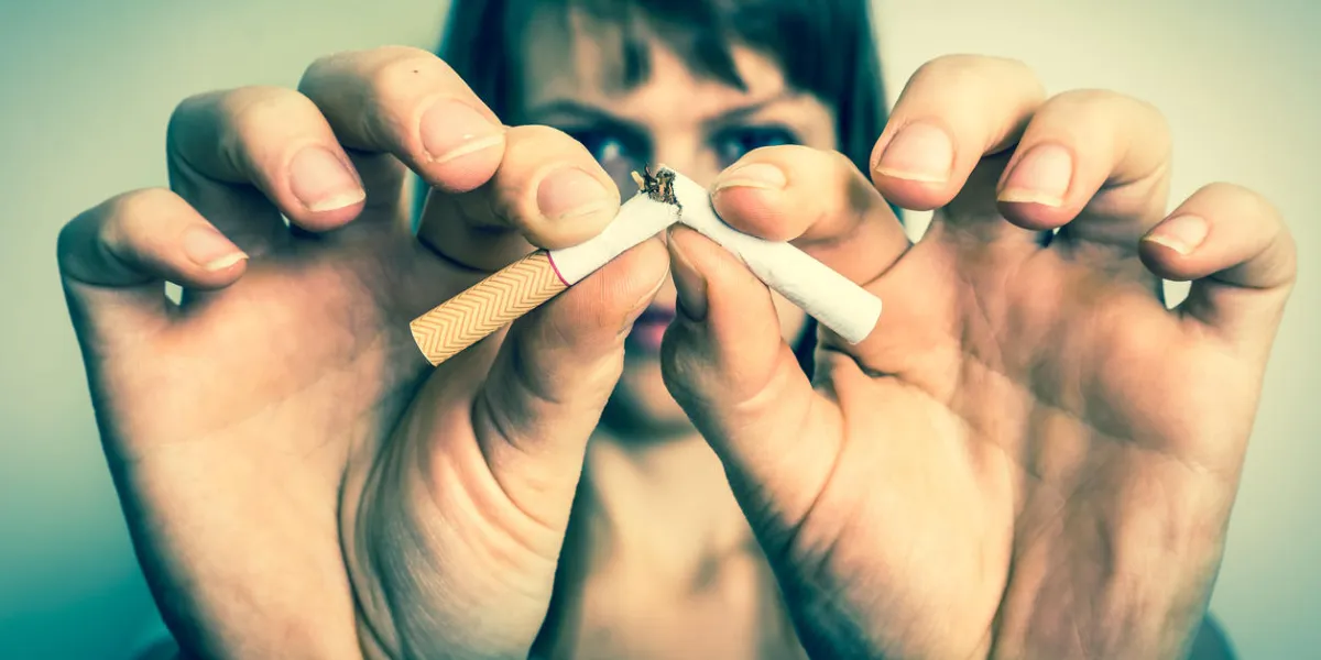 young woman with broken cigarette - stop smoking concept