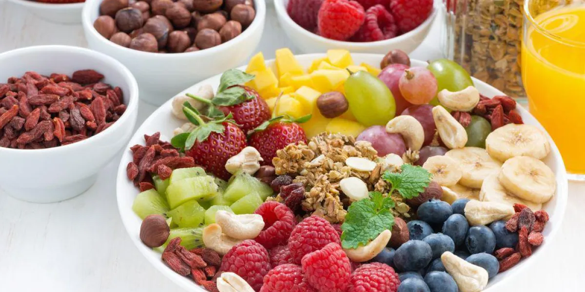 produits pour un petit déjeuner sain - baies, fruits et céréales dans la plaque sur fond blanc, horizontal, gros plan