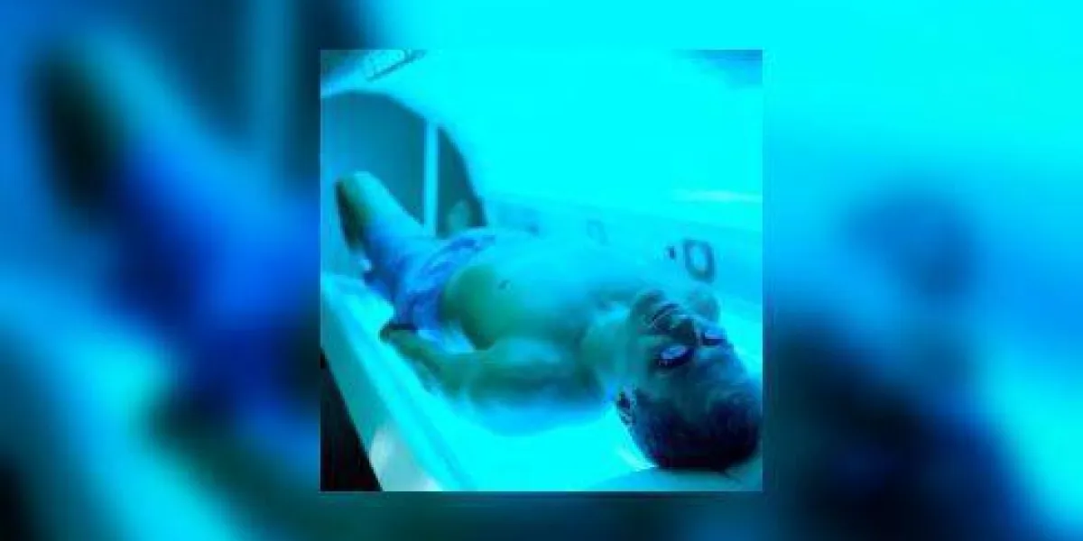 haute vue angle d'un homme allongé dans une machine de bronzage