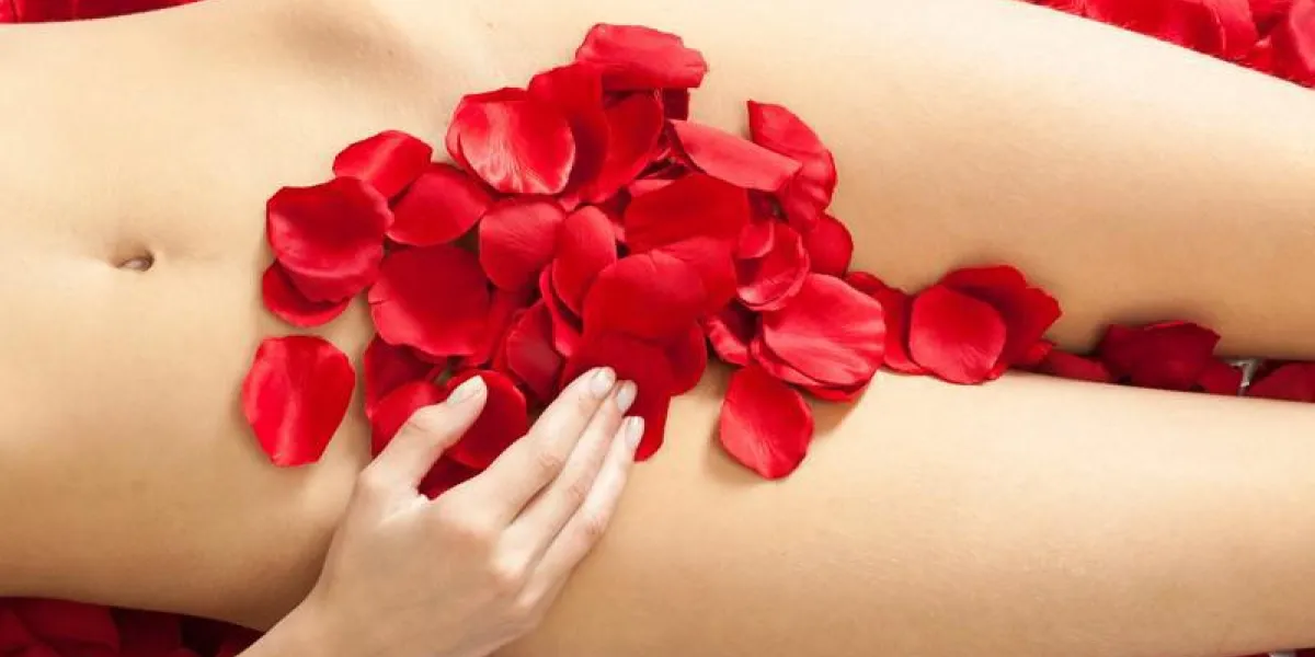 corps féminin avec des pétales de rose rouges