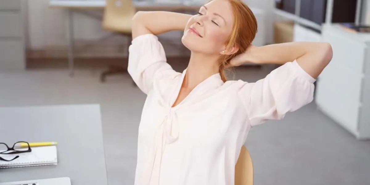 femme au bureau se penchant en arrière détendue femme au bureau se penchant en arrière détendue