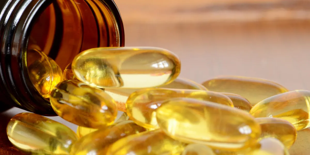 ็heap of transparent yellow capsules pored out from amber bottle ็heap of transparent yellow capsules pored out from amber bottle