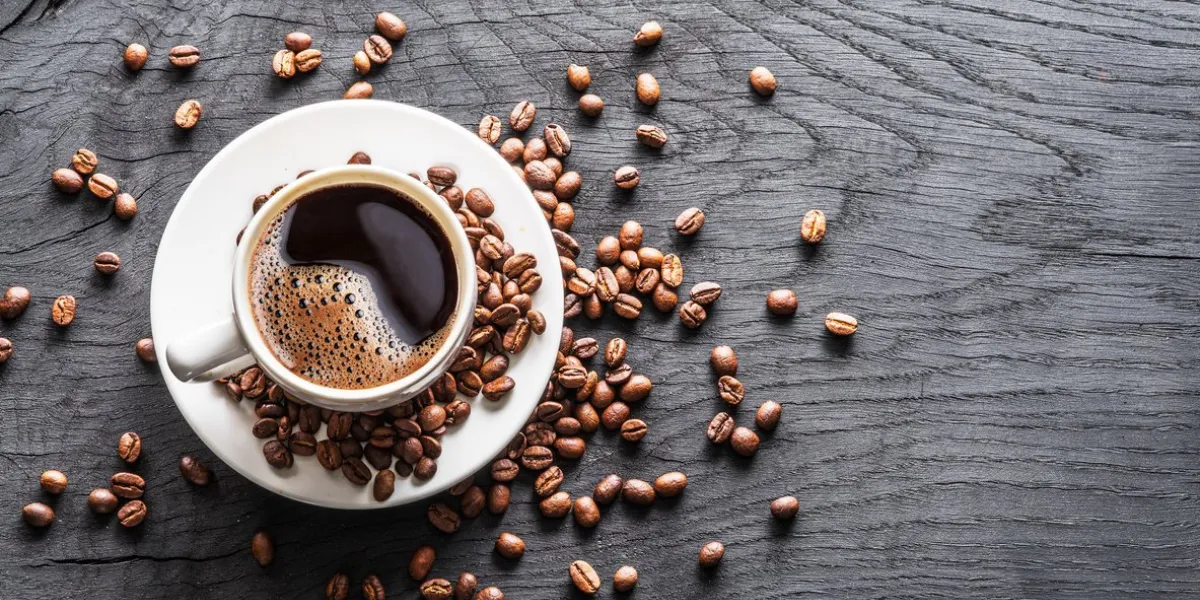cup of coffee surrounded by coffee beans top view cup of coffee surrounded by coffee beans top view