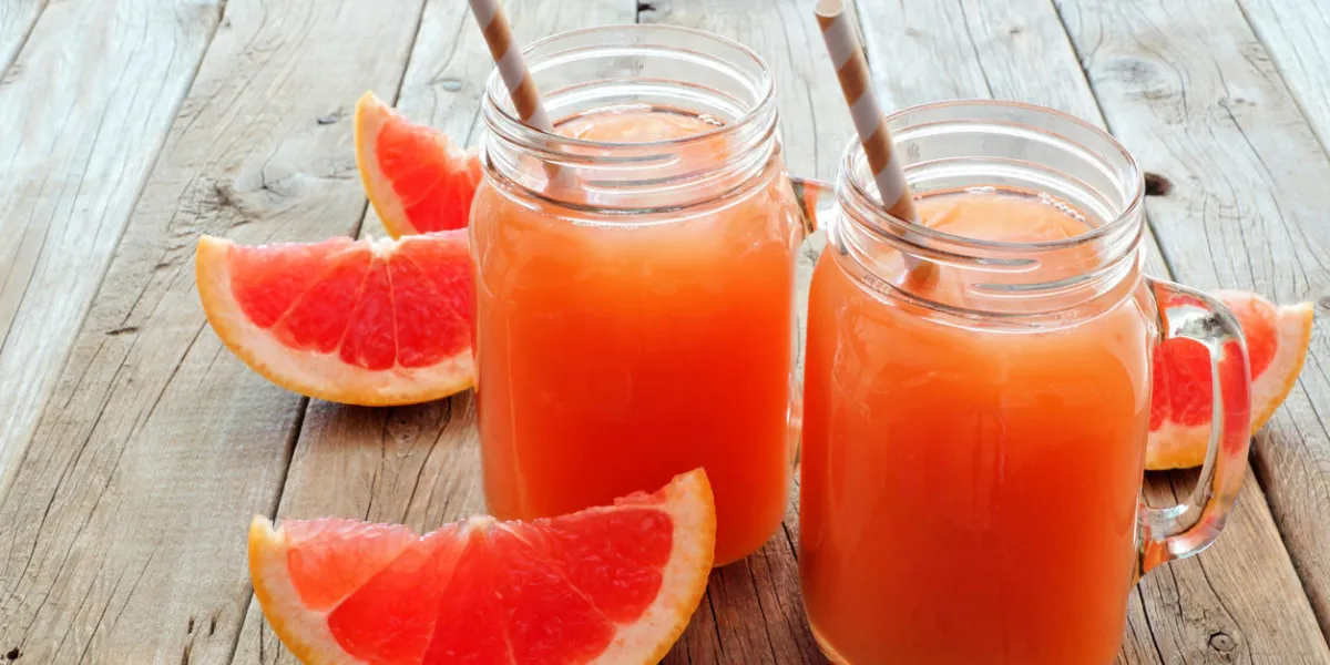 deux verres de pot mason de jus de pamplemousse avec des tranches et des pailles sur fond en bois rustique deux verres de pot mason de jus de pamplemousse avec des tranches et des pailles sur fond en bois rustique