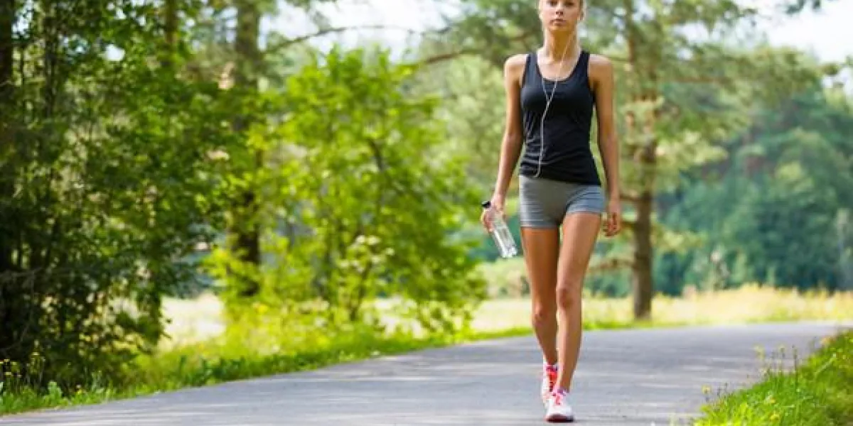 belle jeune femme blonde en forme et marcher sur la piste dans les bois d'entraînement en plein air