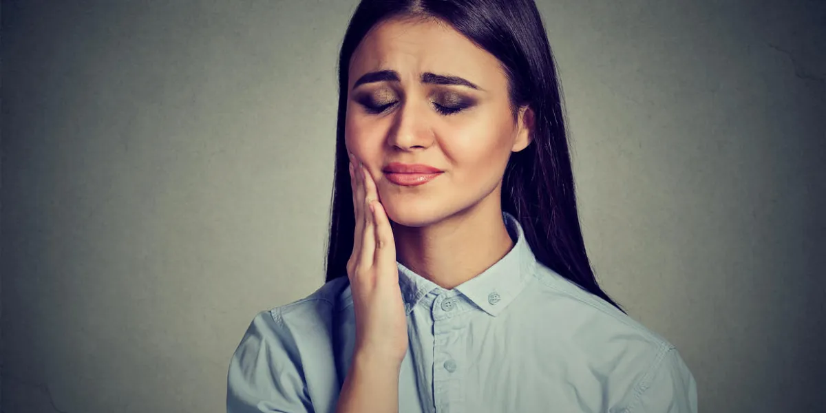 woman with sensitive toothache crown problem suffering from pain touching outside mouth with hand isolated on gray background negative human emotion feelingn woman with sensitive toothache crown problem suffering from pain touching outside mouth with hand isolated on gray background negative human emotion feelingn