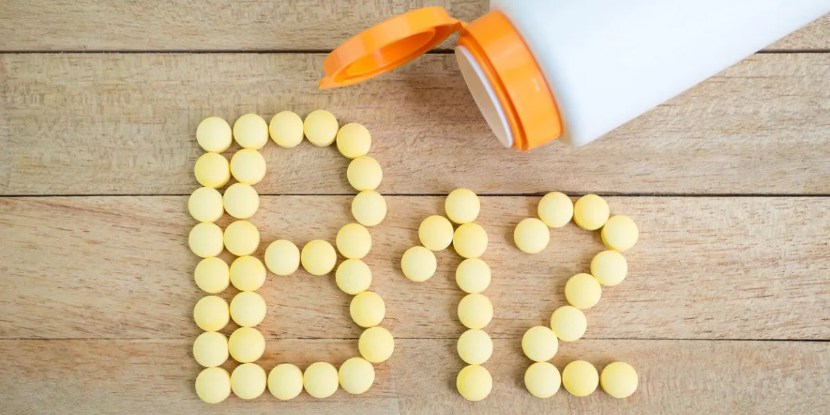 yellow pills forming shape to b12 alphabet on wood background