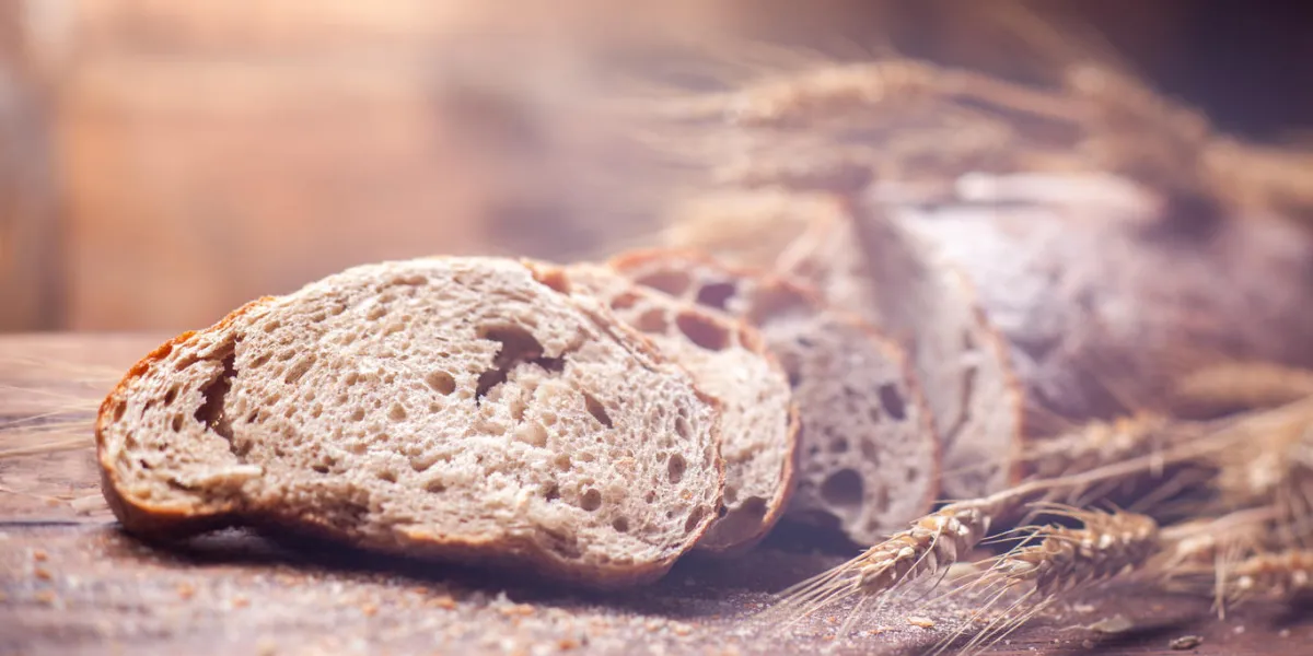 bread and wheat on wooden table, shallow dof, raw image header for website bread and wheat on wooden table, shallow dof, raw image header for website