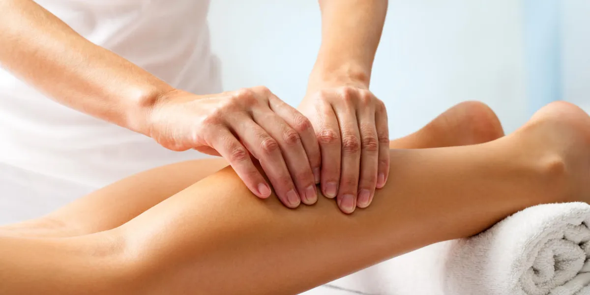 detail of hands massaging human calf muscletherapist applying pressure on female leg