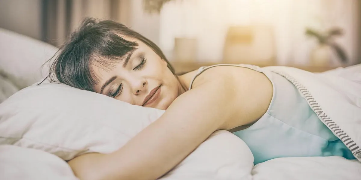 belle jeune femme dormant sur un lit dans la chambre un sommeil paisible vous rend heureux