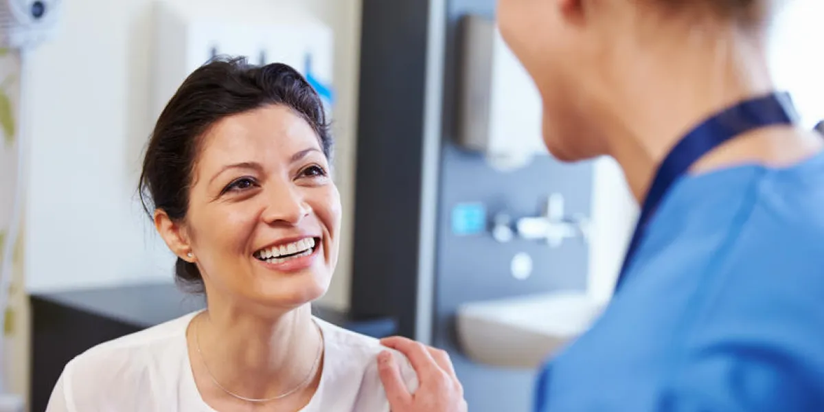 patiente étant rassurée par un médecin dans une chambre d'hôpital