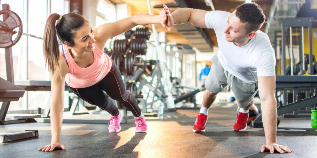 young sporty couple working out together at gym