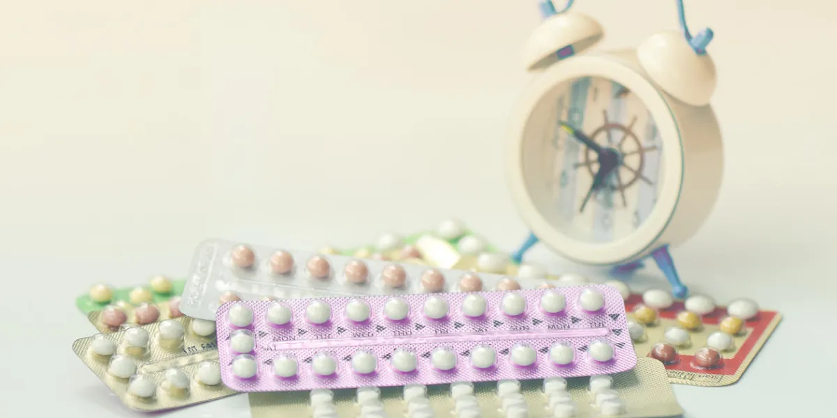 oral contraceptive pills with alarm clock background in time reminder for taking pills oral contraceptive pills with alarm clock background in time reminder for taking pills