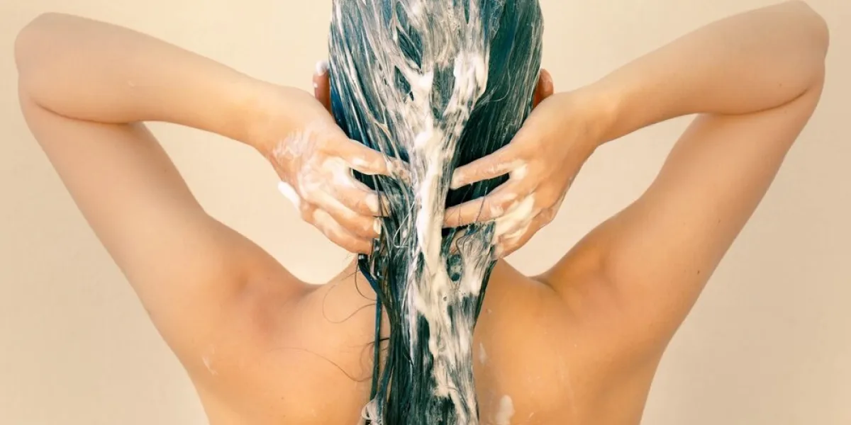 the back of a pretty woman washing her hair in the shower shamp