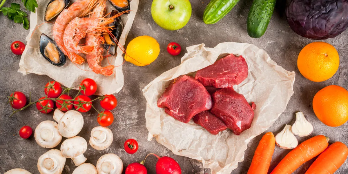 selection of healthy dietary food products - raw beef, seafood, vegetables, fruits and greens on a concrete gray table, top view selection of healthy dietary food products - raw beef, seafood, vegetables, fruits and greens on a concrete gray table, top view