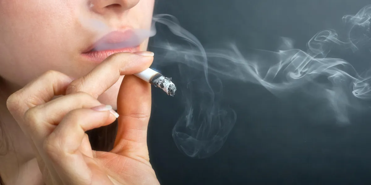 woman with cigarette exhaling smoke woman with cigarette exhaling smoke