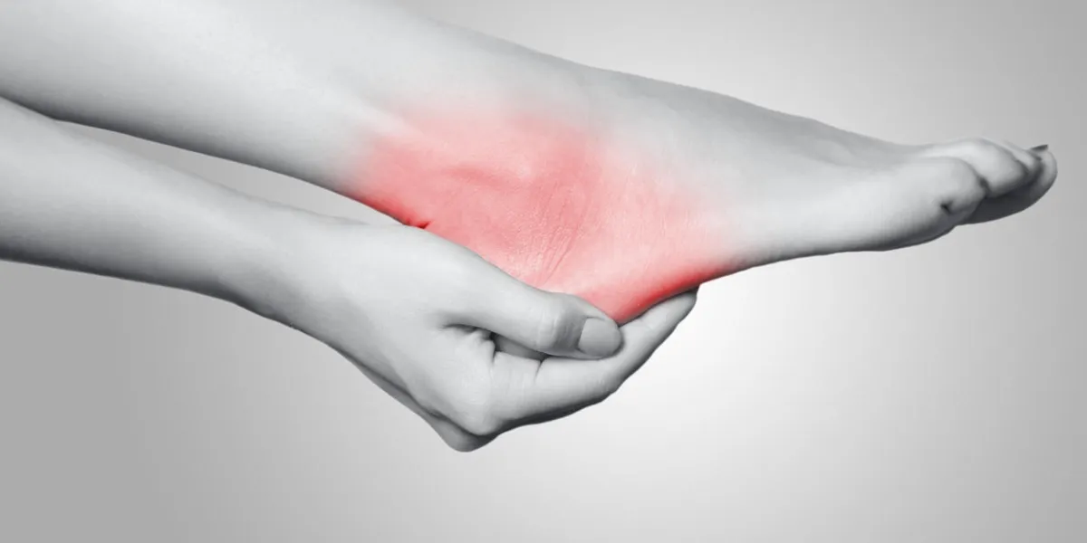 closeup view of a young woman with pain on leg on gray background black and white photo with red dot closeup view of a young woman with pain on leg on gray background black and white photo with red dot