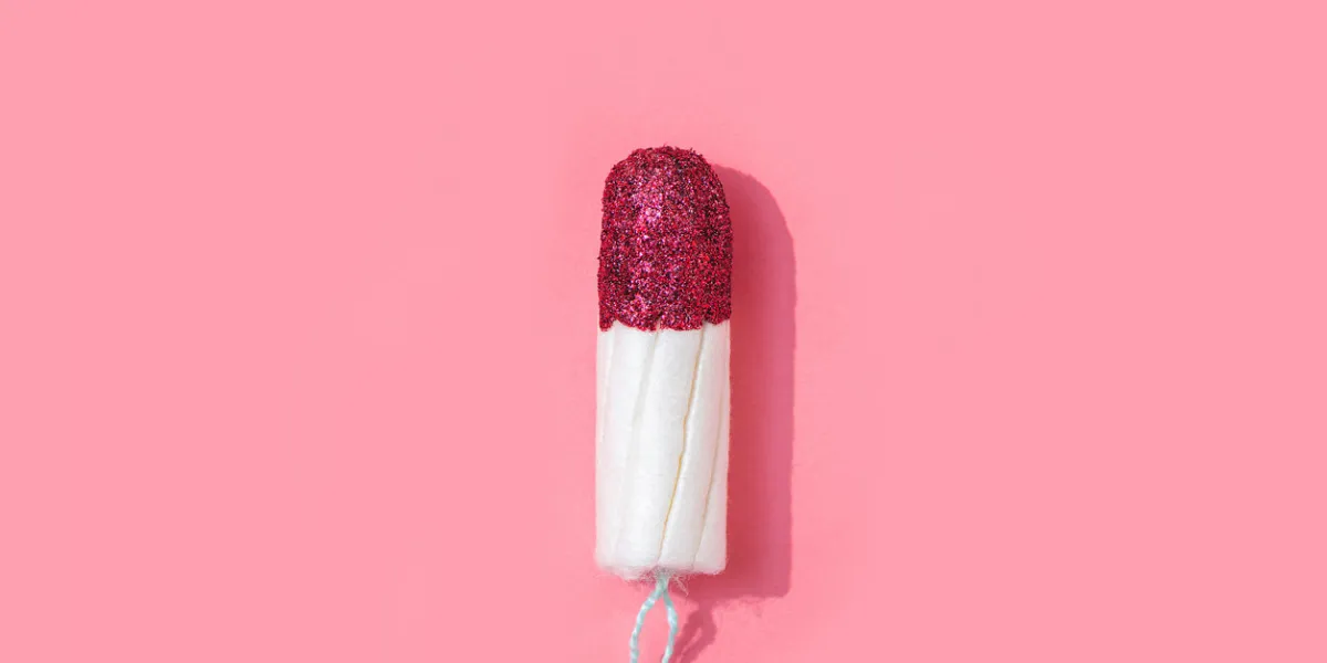 tampon with red glitter instead of blood on pink background