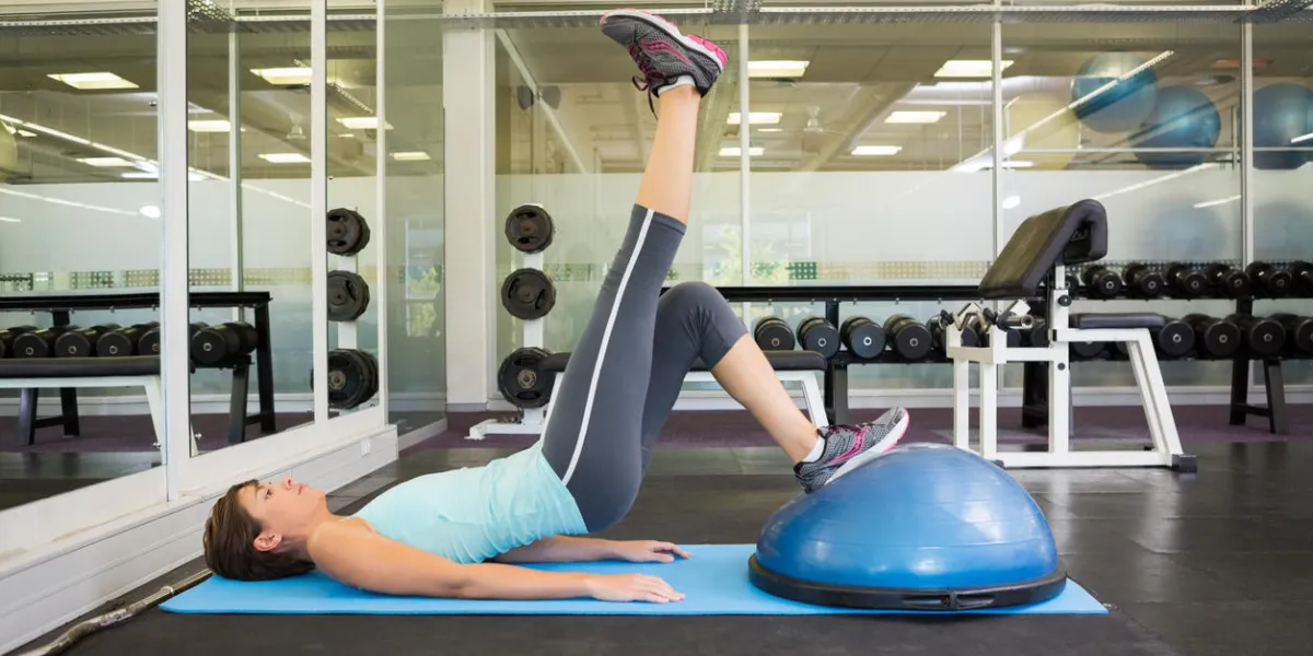 fit brunette using bosu ball to work out at the gym fit brunette using bosu ball to work out at the gym